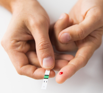 finger prick with blood drop to test for hyperglycemia