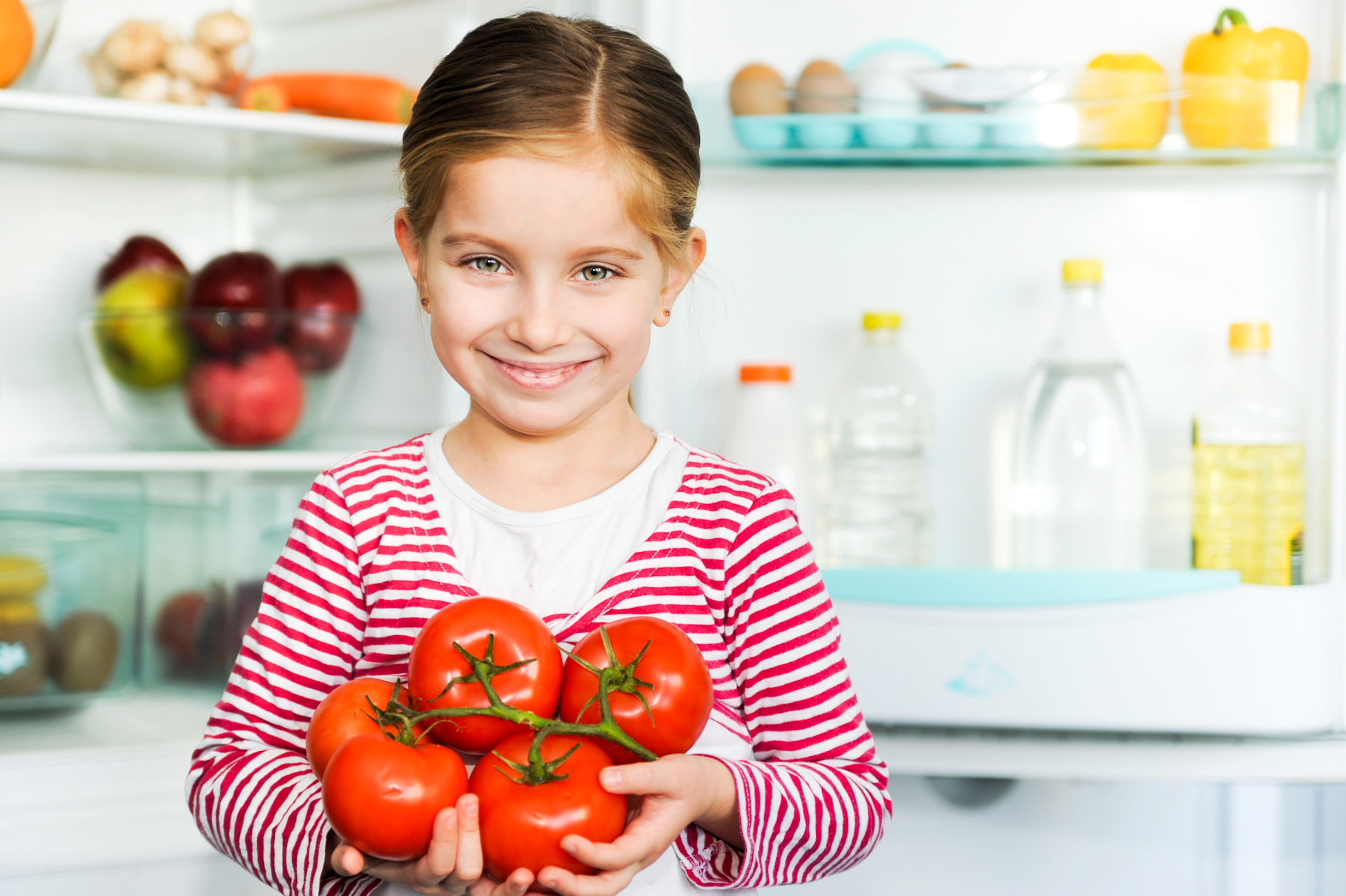 child holding tomatoes
